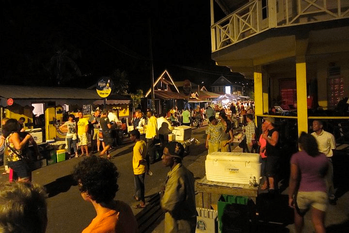 Night street market with people gathered around stalls and food stands.