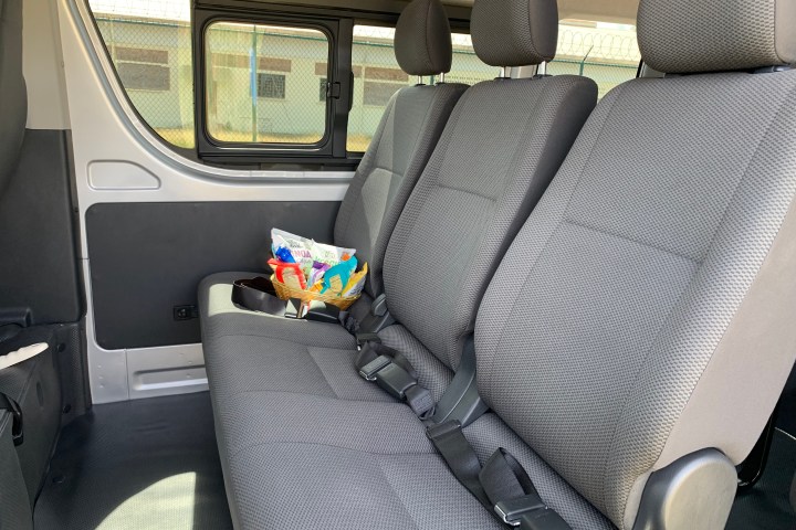 Interior of a van with empty seats and a basket of snacks on one.
