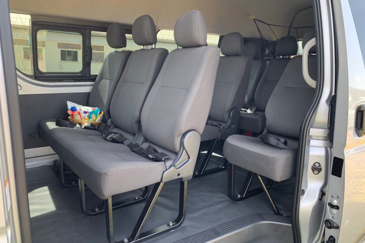 Interior of a van with gray seats and a basket of snacks on the backseat.