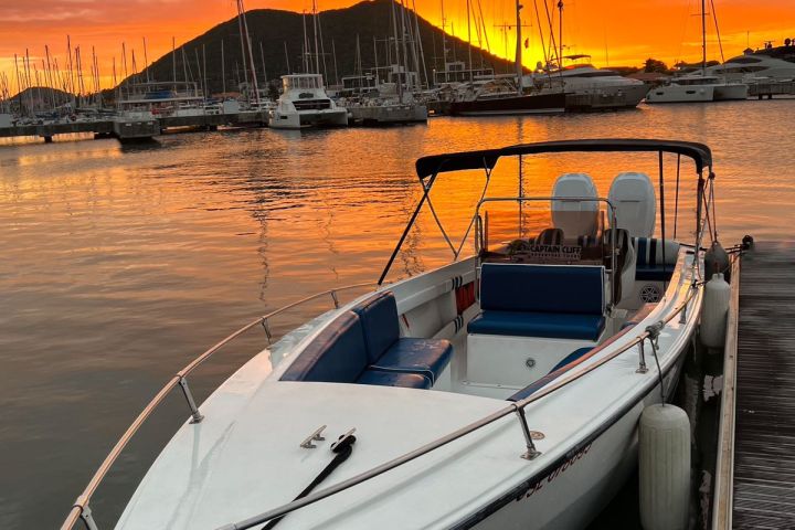 Boat docked with vibrant sunset and marina background.